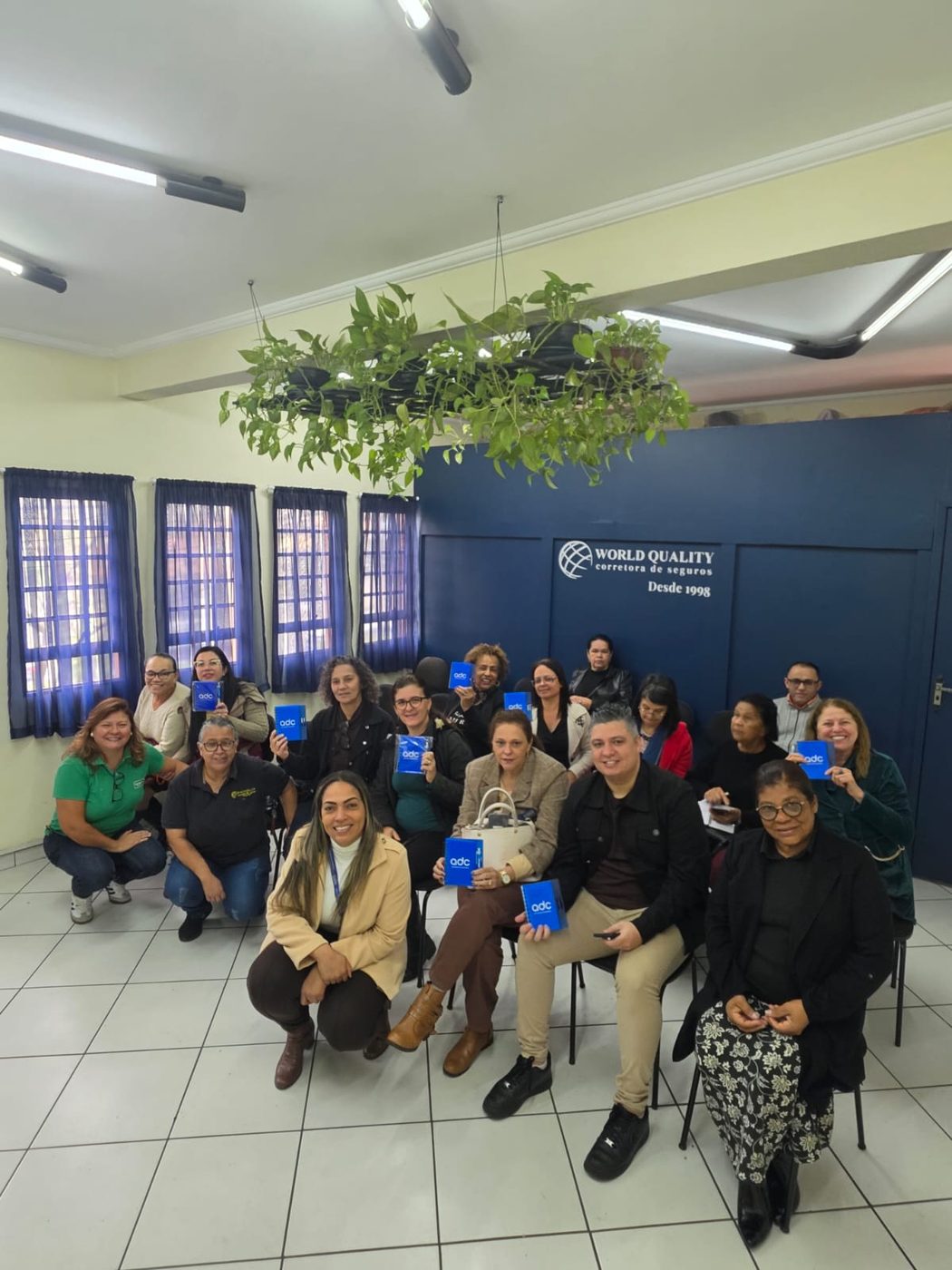 Equipe e parceiros da World Quality diante do logo — desde 1998